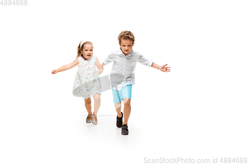 Image of Happy children, little caucasian boy and girl jumping and running isolated on white background