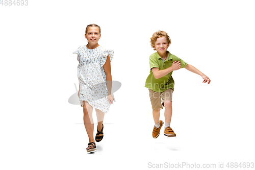 Image of Happy little caucasian girl and boy jumping and running isolated on white background