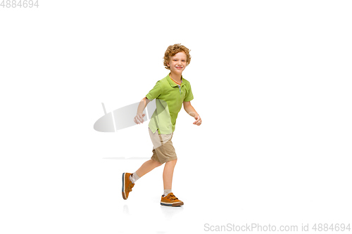 Image of Happy little caucasian boy jumping and running isolated on white background
