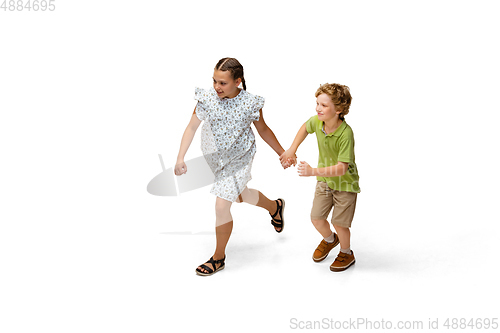 Image of Happy little caucasian girl and boy jumping and running isolated on white background