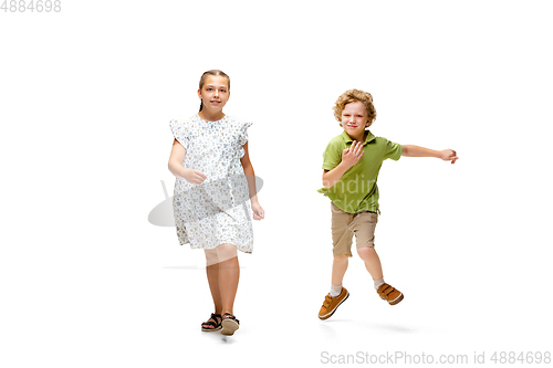 Image of Happy little caucasian girl and boy jumping and running isolated on white background