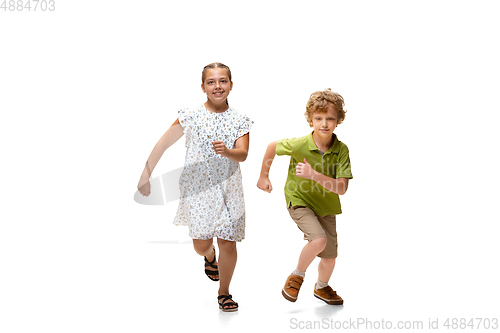 Image of Happy little caucasian girl and boy jumping and running isolated on white background