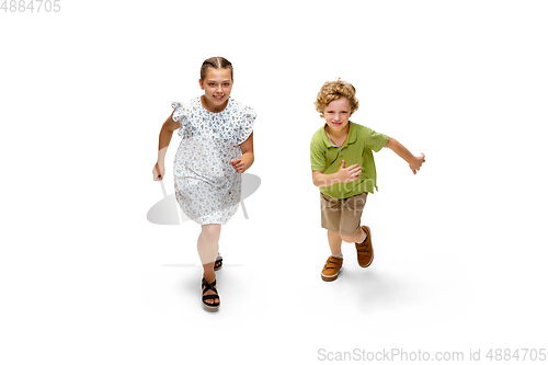 Image of Happy little caucasian girl and boy jumping and running isolated on white background