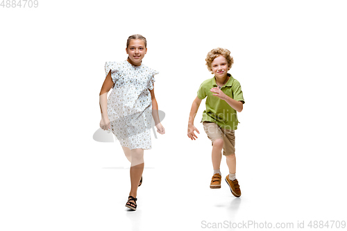 Image of Happy little caucasian girl and boy jumping and running isolated on white background