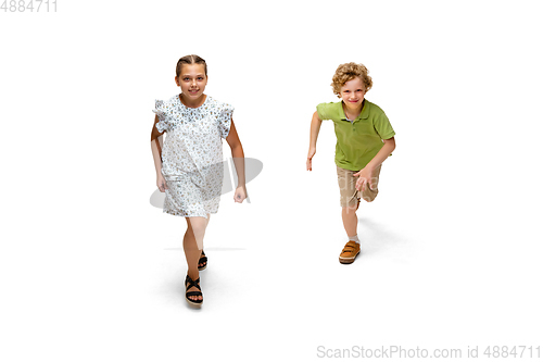 Image of Happy little caucasian girl and boy jumping and running isolated on white background