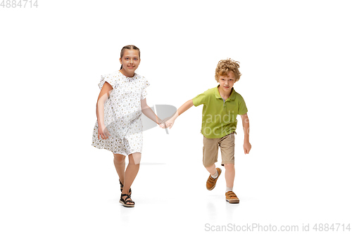 Image of Happy little caucasian girl and boy jumping and running isolated on white background