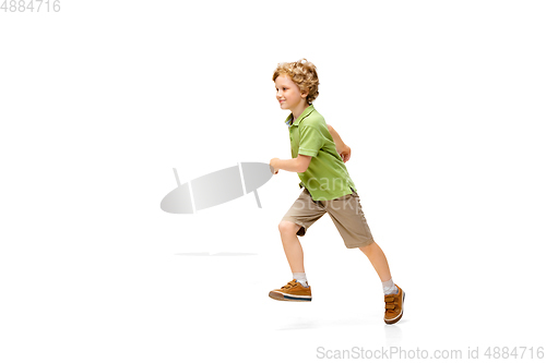 Image of Happy little caucasian boy jumping and running isolated on white background