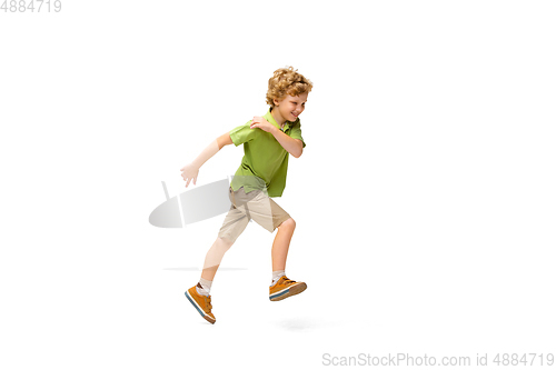 Image of Happy little caucasian boy jumping and running isolated on white background