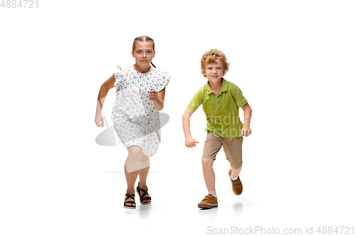 Image of Happy little caucasian girl and boy jumping and running isolated on white background