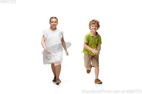 Image of Happy little caucasian girl and boy jumping and running isolated on white background