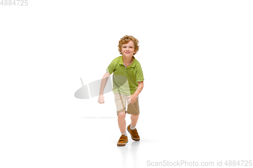 Image of Happy little caucasian boy jumping and running isolated on white background