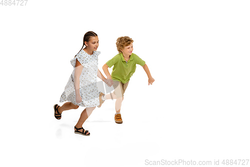 Image of Happy little caucasian girl and boy jumping and running isolated on white background