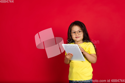 Image of Beautiful emotional little girl isolated on red background. Half-lenght portrait of happy child gesturing