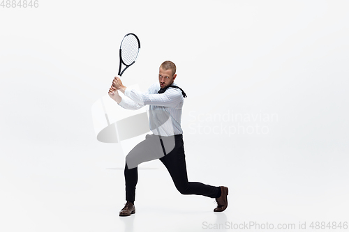 Image of Time for movement. Man in office clothes plays tennis isolated on white studio background.