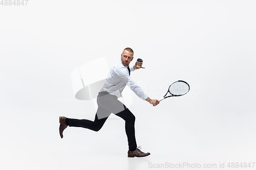 Image of Time for movement. Man in office clothes plays tennis isolated on white studio background.