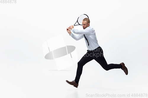 Image of Time for movement. Man in office clothes plays tennis isolated on white studio background.