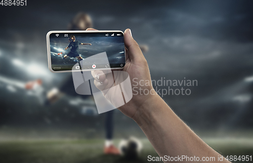 Image of Close up hands holding smartphone viewing sport, online translation, streaming of championship