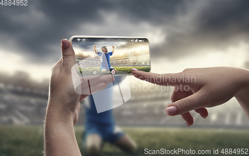 Image of Close up hands holding smartphone viewing sport, online translation, streaming of championship