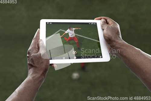 Image of Close up hands holding tablet viewing sport, online translation, streaming of championship