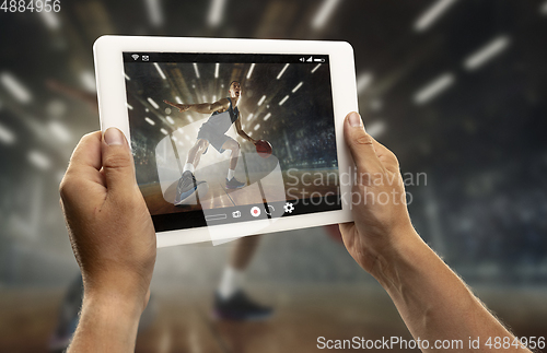 Image of Close up hands holding tablet viewing sport, online translation, streaming of championship