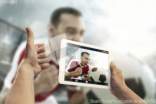 Image of Close up hands holding tablet viewing sport, online translation, streaming of championship