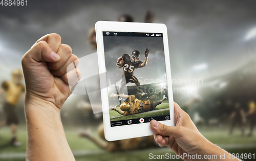 Image of Close up hands holding tablet viewing sport, online translation, streaming of championship