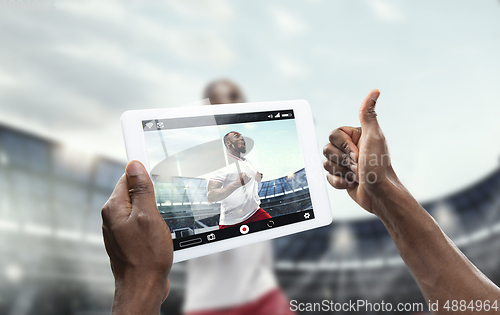 Image of Close up hands holding tablet viewing sport, online translation, streaming of championship