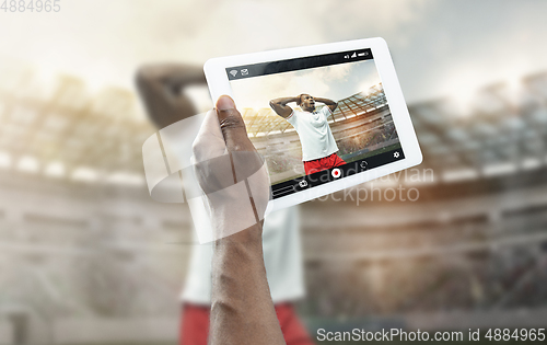 Image of Close up hands holding tablet viewing sport, online translation, streaming of championship