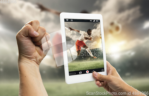 Image of Close up hands holding tablet viewing sport, online translation, streaming of championship