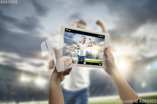 Image of Close up hands holding tablet viewing sport, online translation, streaming of championship