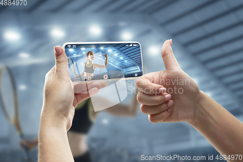 Image of Close up hands holding smartphone viewing sport, online translation, streaming of championship