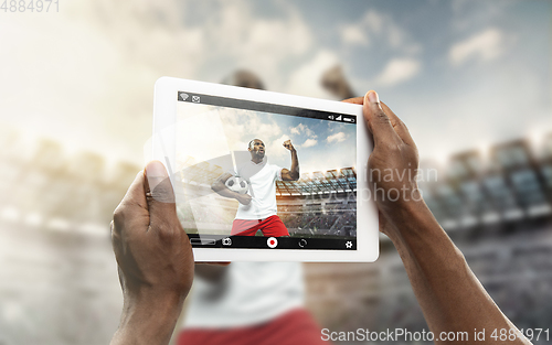 Image of Close up hands holding tablet viewing sport, online translation, streaming of championship