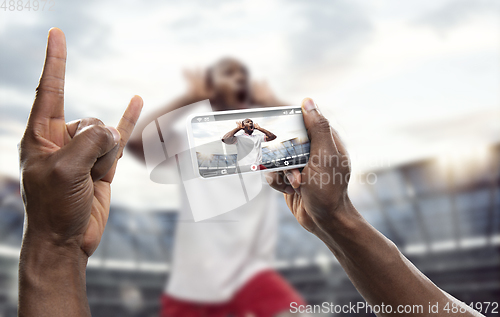 Image of Close up hands holding smartphone viewing sport, online translation, streaming of championship