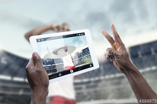 Image of Close up hands holding tablet viewing sport, online translation, streaming of championship