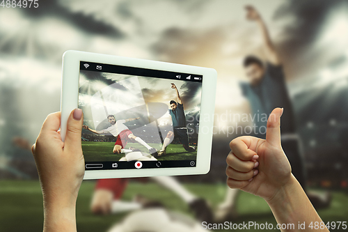 Image of Close up hands holding tablet viewing sport, online translation, streaming of championship