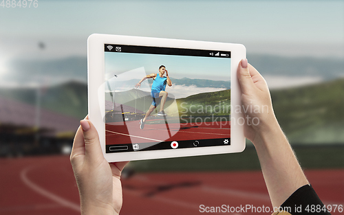 Image of Close up hands holding tablet viewing sport, online translation, streaming of championship