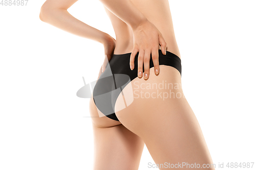 Image of Beautiful female legs, buttlocks and belly isolated on white background. Sportive, sensual body with well-kept skin in underwear.