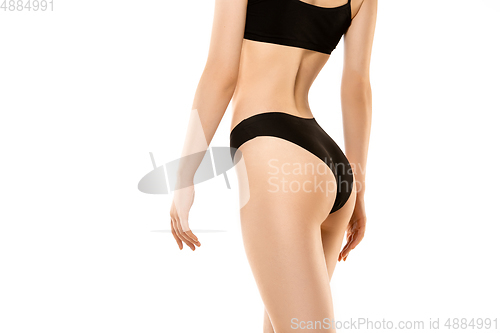 Image of Beautiful female legs, buttlocks and belly isolated on white background. Sportive, sensual body with well-kept skin in underwear.