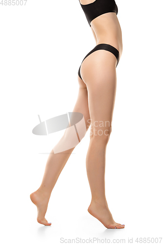 Image of Beautiful female legs, buttlocks and belly isolated on white background. Sportive, sensual body with well-kept skin in underwear.