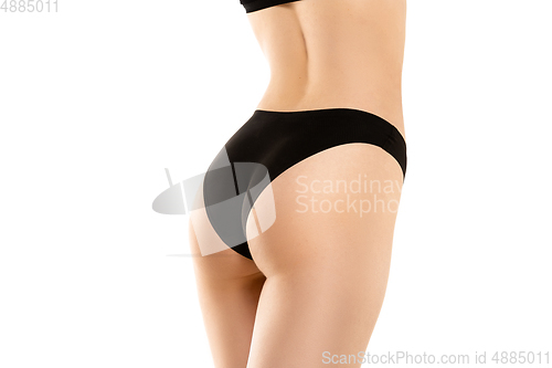 Image of Beautiful female legs, buttlocks and belly isolated on white background. Sportive, sensual body with well-kept skin in underwear.
