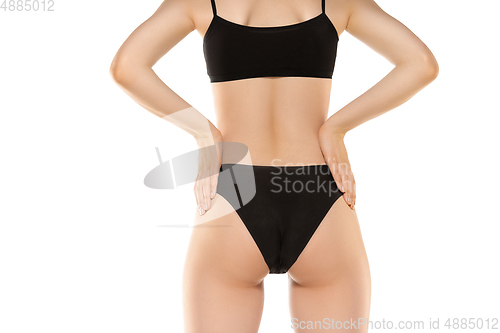 Image of Beautiful female legs, buttlocks and belly isolated on white background. Sportive, sensual body with well-kept skin in underwear.