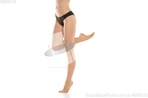 Image of Beautiful female legs, buttlocks and belly isolated on white background. Sportive, sensual body with well-kept skin in underwear.