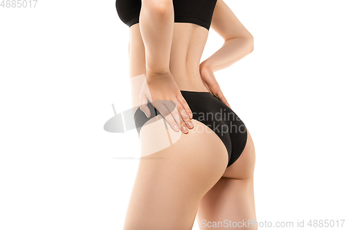 Image of Beautiful female legs, buttlocks and belly isolated on white background. Sportive, sensual body with well-kept skin in underwear.