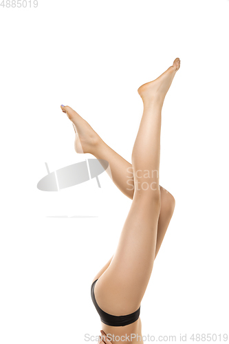 Image of Beautiful female legs, buttlocks and belly isolated on white background. Sportive, sensual body with well-kept skin in underwear.