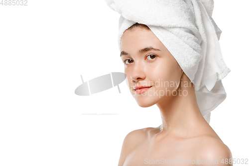 Image of Beauty Day. Woman wearing towel doing her daily skincare routine isolated on white studio background