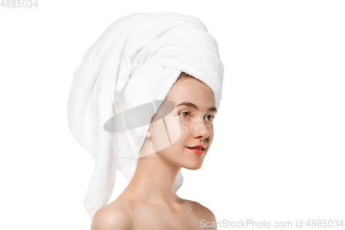 Image of Beauty Day. Woman wearing towel doing her daily skincare routine isolated on white studio background