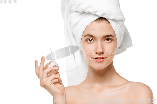 Image of Beauty Day. Woman wearing towel doing her daily skincare routine isolated on white studio background