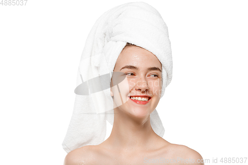 Image of Beauty Day. Woman wearing towel doing her daily skincare routine isolated on white studio background