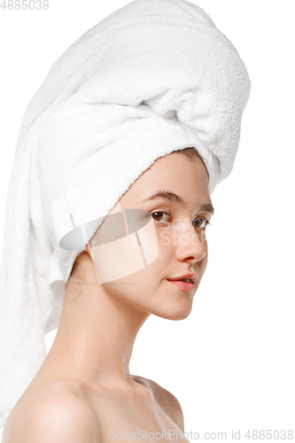 Image of Beauty Day. Woman wearing towel doing her daily skincare routine isolated on white studio background