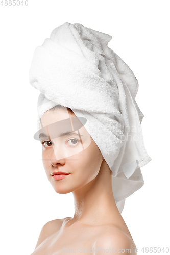 Image of Beauty Day. Woman wearing towel doing her daily skincare routine isolated on white studio background